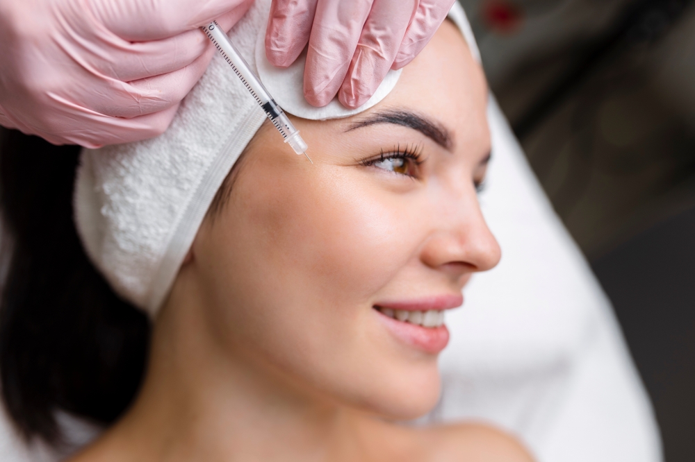 Close-up of a woman receiving a cosmetic injection, featuring a gloved hand administering treatment with a syringe. The woman has a serene expression, showcasing the skincare process in a professional setting.